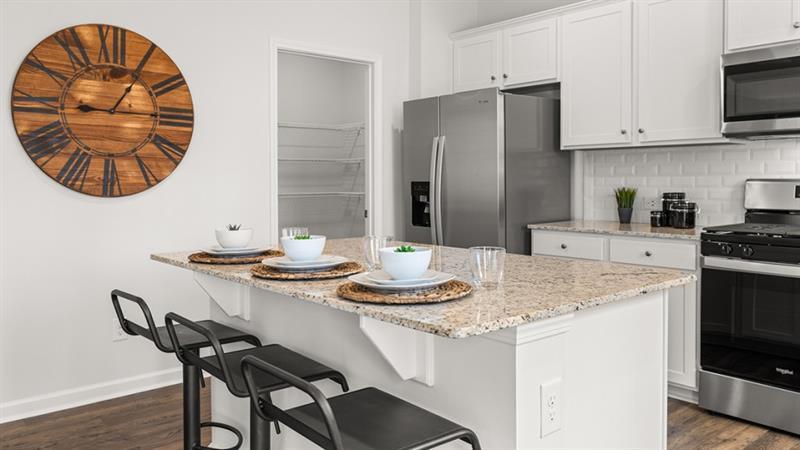 74 Buckthorn Way Dallas, GA 30132 - Photo 5 of 37 a kitchen with stainless steel appliances kitchen island a table and chairs in it