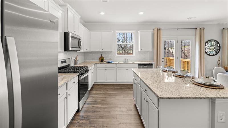 74 Buckthorn Way Dallas, GA 30132 - Photo 6 of 37 a kitchen with granite countertop a sink stove refrigerator and cabinets