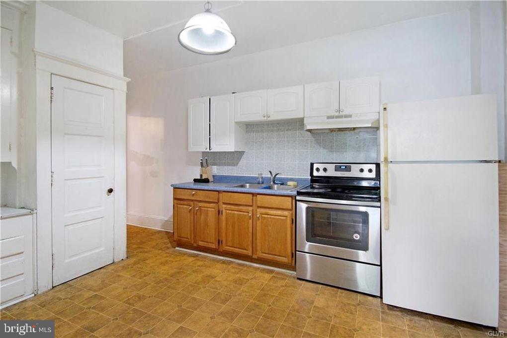 516 Carlton Avenue Bethlehem, PA 18015 - Photo 8 of 12 a kitchen with stainless steel appliances granite countertop a stove and a refrigerator
