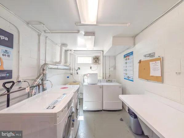 a room with a sink a stove and white cabinets