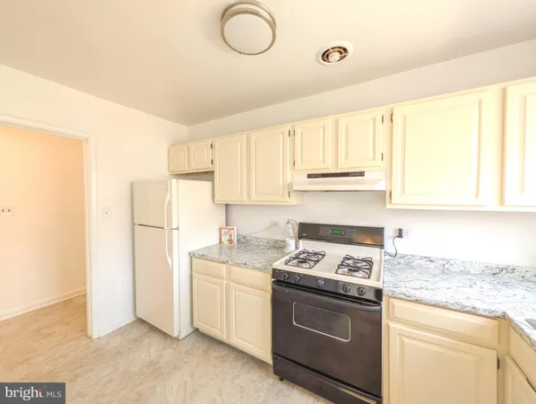 a kitchen with a stove cabinets and a refrigerator
