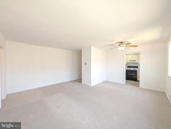 an empty room with kitchen view and a window