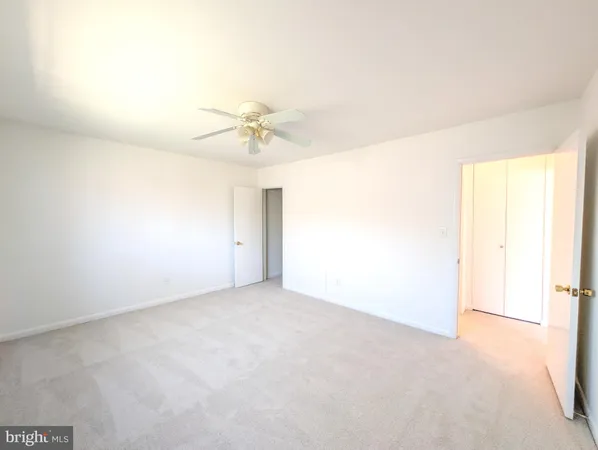 an empty room with a ceiling fan and a window