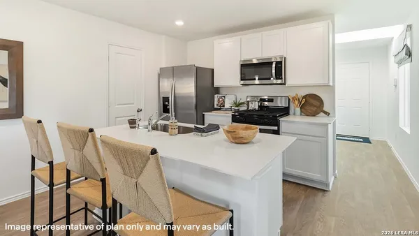 a kitchen with stainless steel appliances granite countertop a table chairs and a refrigerator