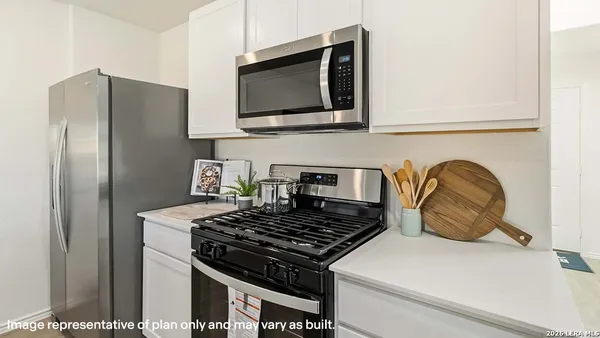 a kitchen with stainless steel appliances granite countertop a refrigerator and a stove top oven
