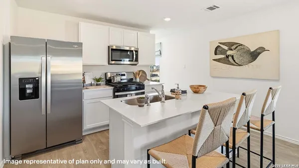 a kitchen with stainless steel appliances kitchen island granite countertop a refrigerator a stove a microwave a sink and a refrigerator