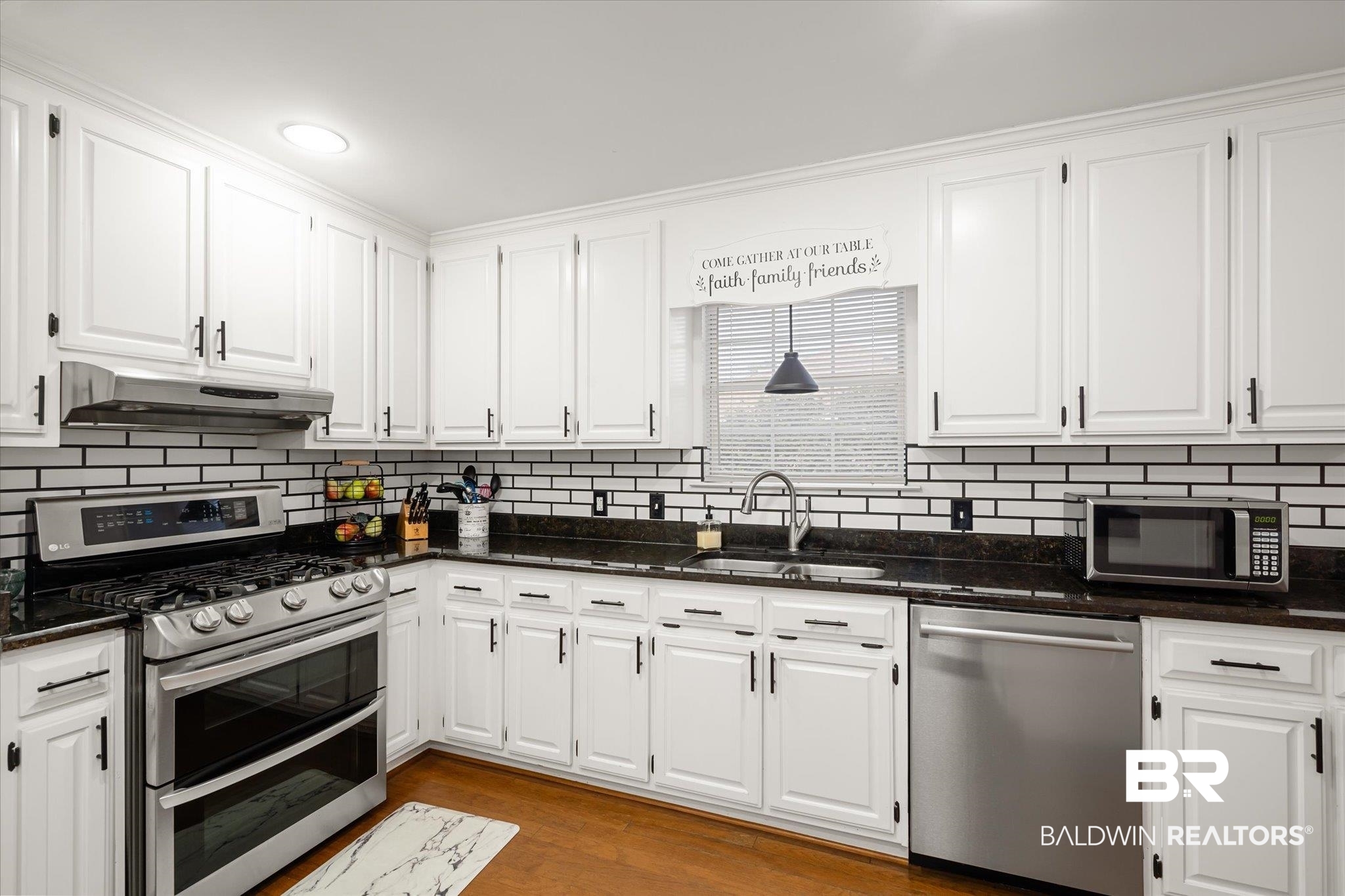 19924 Hunters Loop Fairhope, AL 36532 - Photo 10 of 40 Kitchen featuring white cabinetry, sink, backsplash, light hardwood / wood-style floors, and appliances with stainless steel finishes