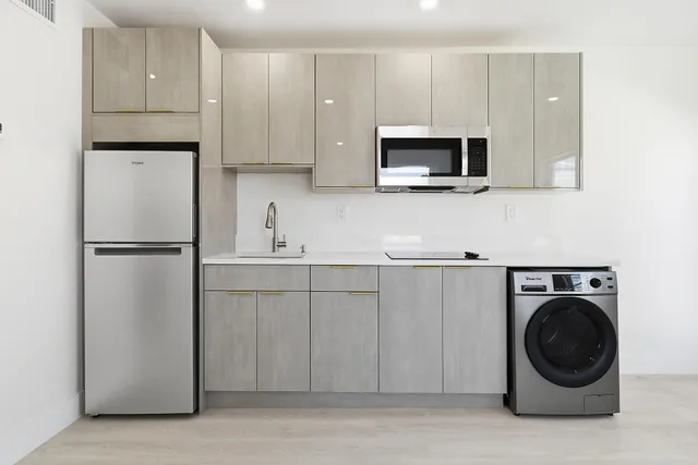 a kitchen with white cabinets and stainless steel appliances