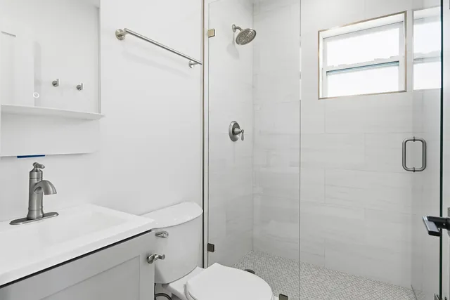 a bathroom with a sink a toilet and shower