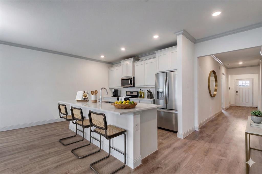 332 Braves Way Lavon, TX 75166 - Photo 4 of 24 a kitchen with stainless steel appliances granite countertop a refrigerator a stove a sink dishwasher and a refrigerator with wooden floor