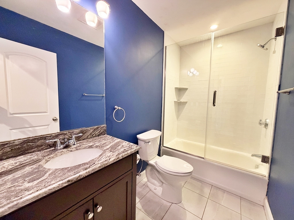 266 Lexington Street, Unit 1 Boston, MA 02128 - Photo 13 of 19 a bathroom with a granite countertop sink toilet and shower
