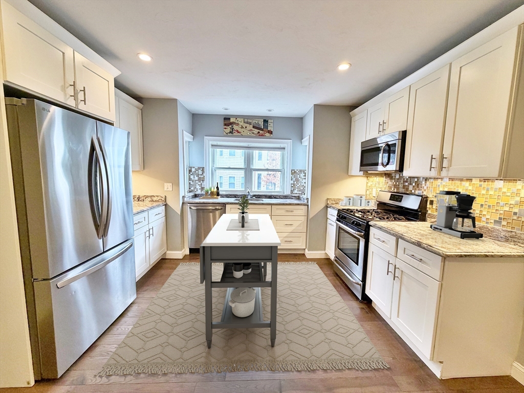 266 Lexington Street, Unit 1 Boston, MA 02128 - Photo 2 of 19 a kitchen with stainless steel appliances granite countertop a refrigerator a sink a stove and white cabinets