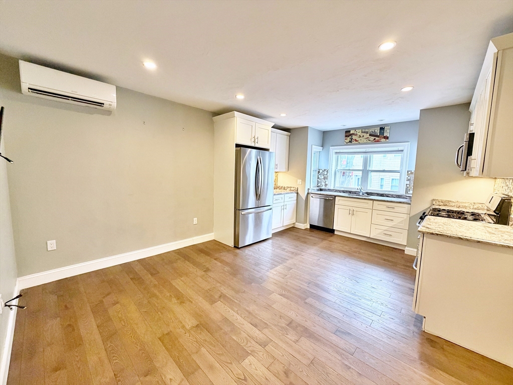 266 Lexington Street, Unit 1 Boston, MA 02128 - Photo 5 of 19 a view of a kitchen with a stove cabinets and wooden floor