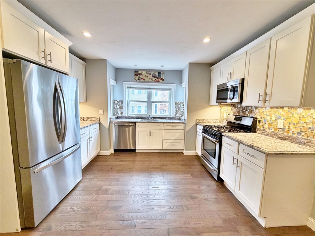 266 Lexington Street, Unit 1 Boston, MA 02128 - Photo 7 of 19 a kitchen with granite countertop a refrigerator stove top oven and sink