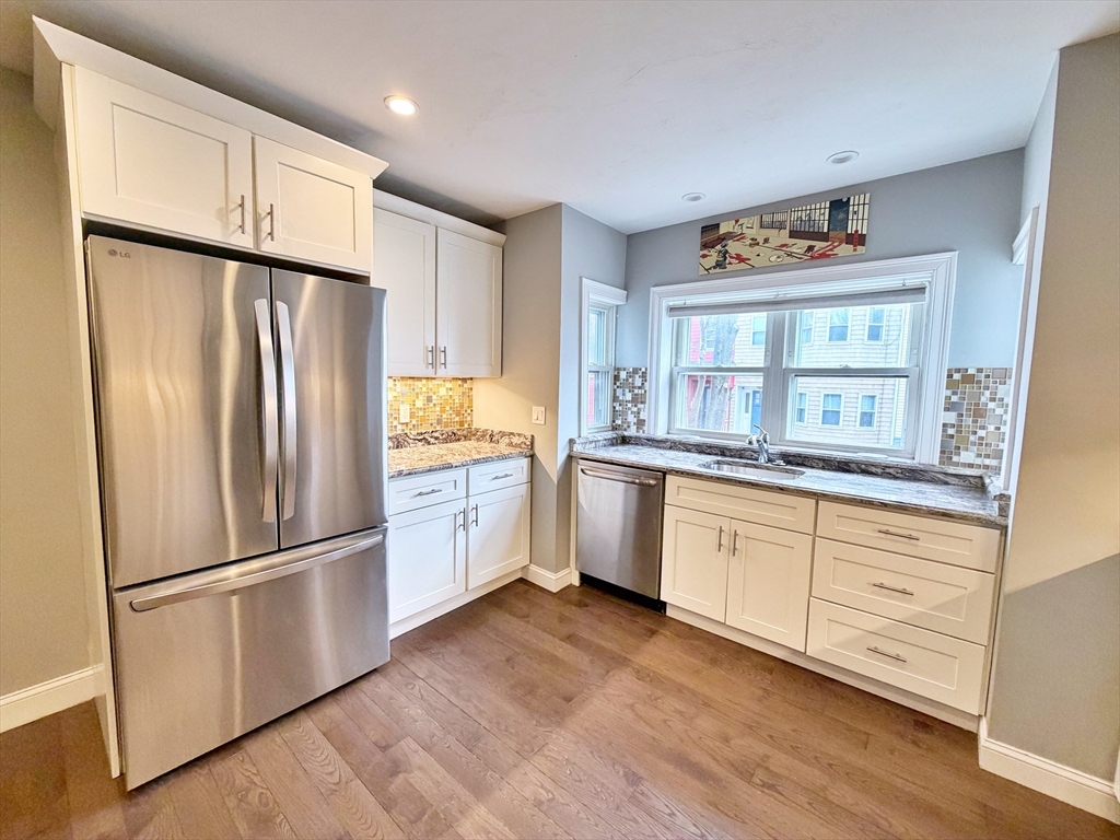 266 Lexington Street, Unit 1 Boston, MA 02128 - Photo 8 of 19 a kitchen with granite countertop stainless steel appliances a refrigerator and cabinets