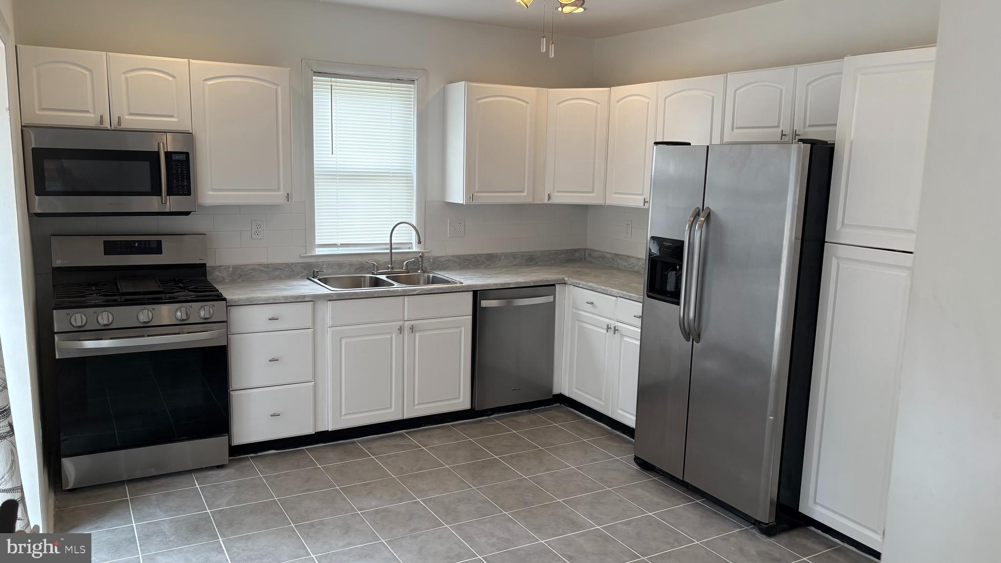 1776 North Tuckahoe Road Williamstown, NJ 08094 - Photo 6 of 14 a kitchen with white cabinets and stainless steel appliances