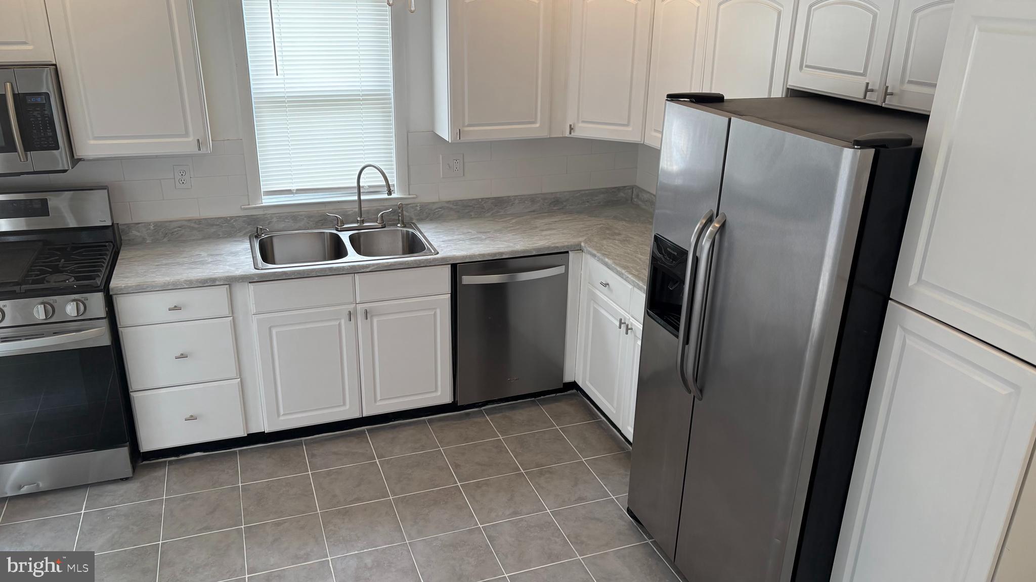 1776 North Tuckahoe Road Williamstown, NJ 08094 - Photo 7 of 14 a kitchen with a refrigerator sink and cabinets