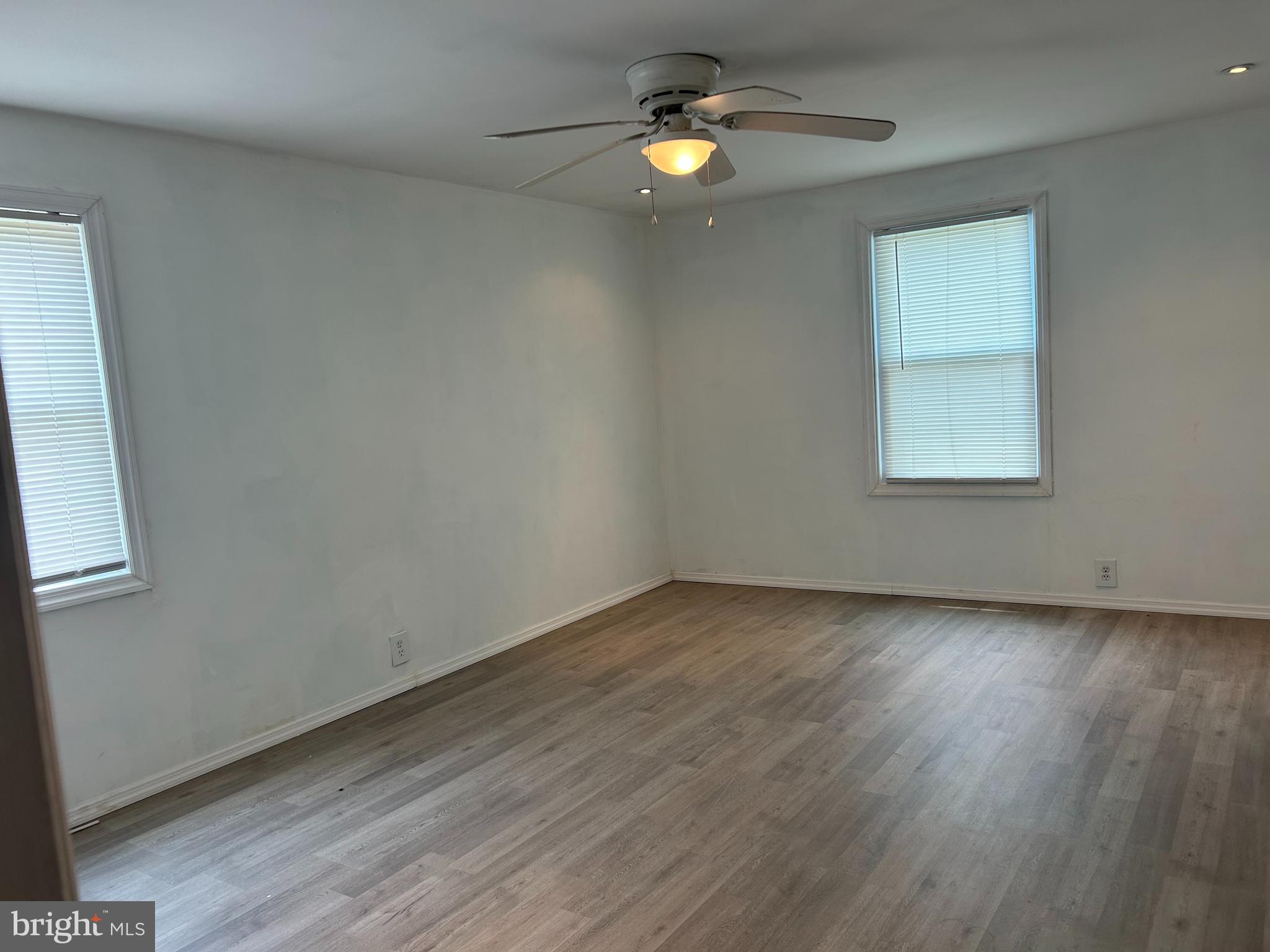1776 North Tuckahoe Road Williamstown, NJ 08094 - Photo 9 of 14 an empty room with wooden floor chandelier fan and windows