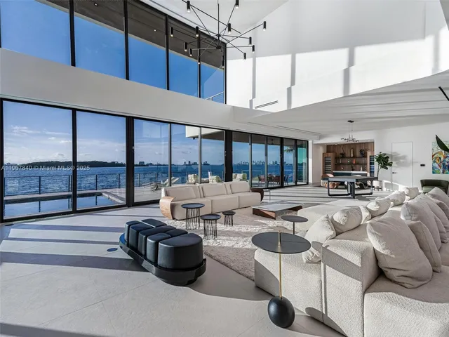 a living room with stainless steel appliances furniture a large window and a wooden floor