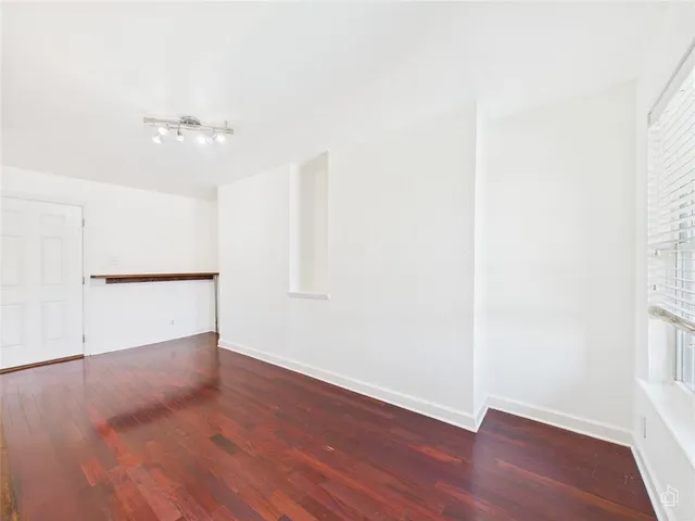 an empty room with wooden floor and ceiling fan