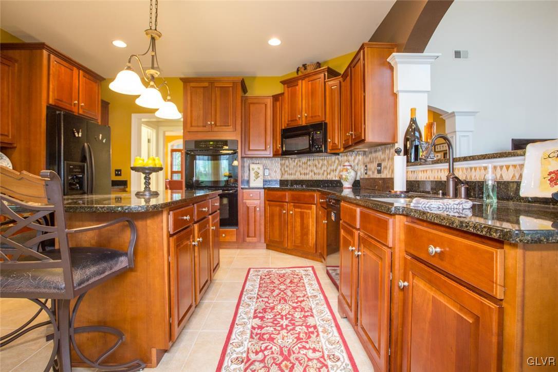 216 East Dell Road Bath, PA 18014 - Photo 14 of 42 a large kitchen with stainless steel appliances kitchen island granite countertop a stove a sink dishwasher and cabinets with wooden floor