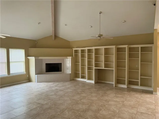 a view of an empty room with a fireplace and a window