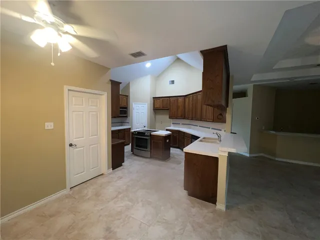 a large kitchen with a large counter top and stainless steel appliances