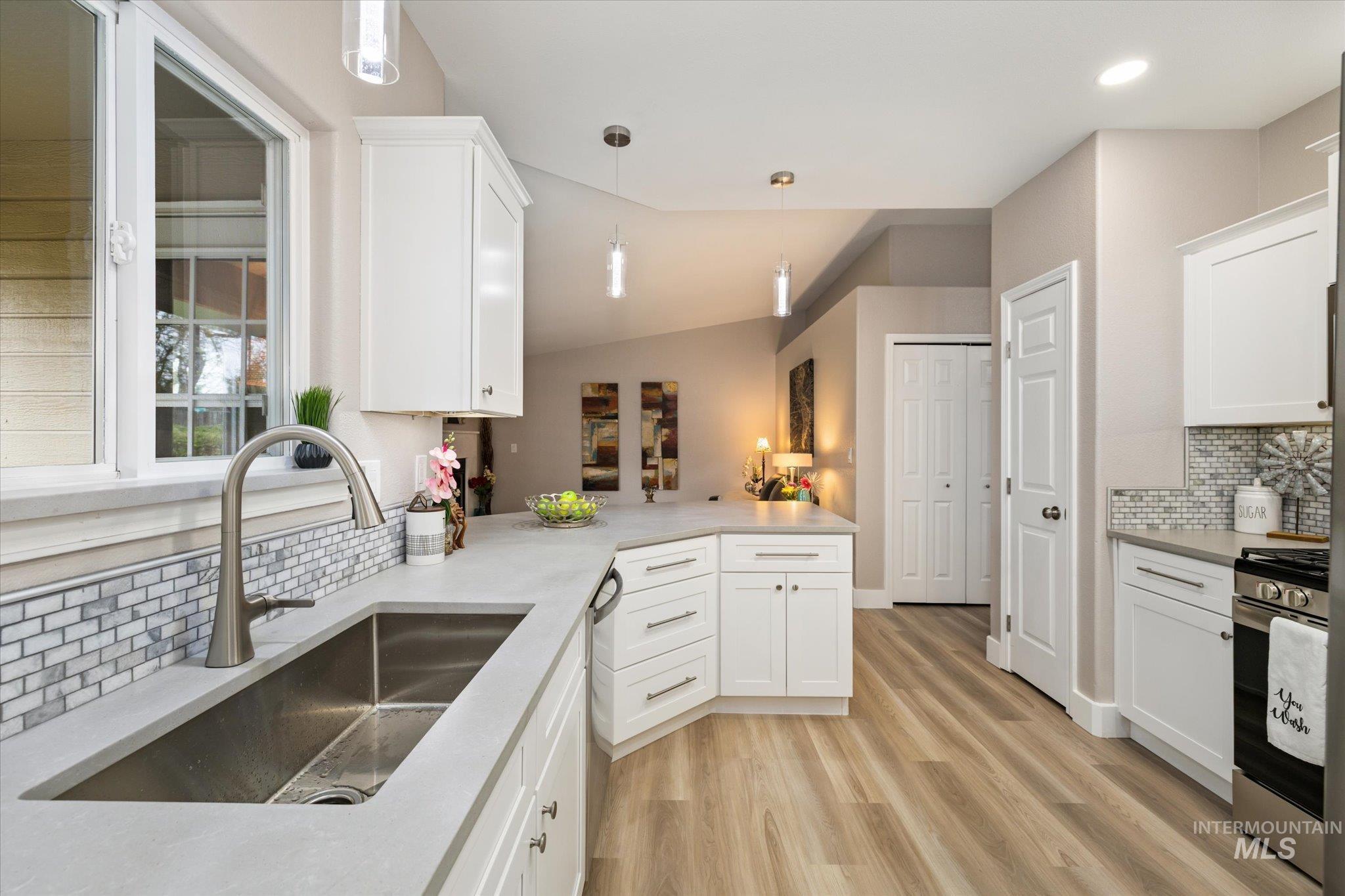 2250 North Amethyst Avenue Meridian, ID 83646 - Photo 14 of 50 Kitchen featuring backsplash, white cabinetry, vaulted ceiling, stainless steel appliances, and pendant lighting