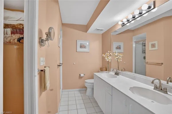 a bathroom with a double vanity sink mirror and toilet