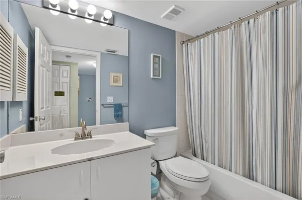 a bathroom with a toilet a sink and a mirror