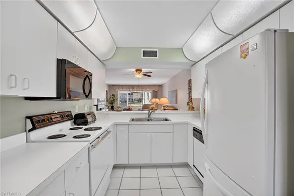 a kitchen with a sink a refrigerator and cabinets