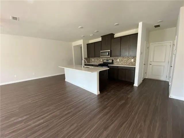 a kitchen with stainless steel appliances a stove top oven and cabinets