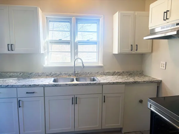 a kitchen with granite countertop cabinets stainless steel appliances and a window