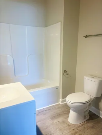 a white toilet sitting next to a bath tub