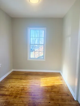 a view of a room with wooden floor and a window