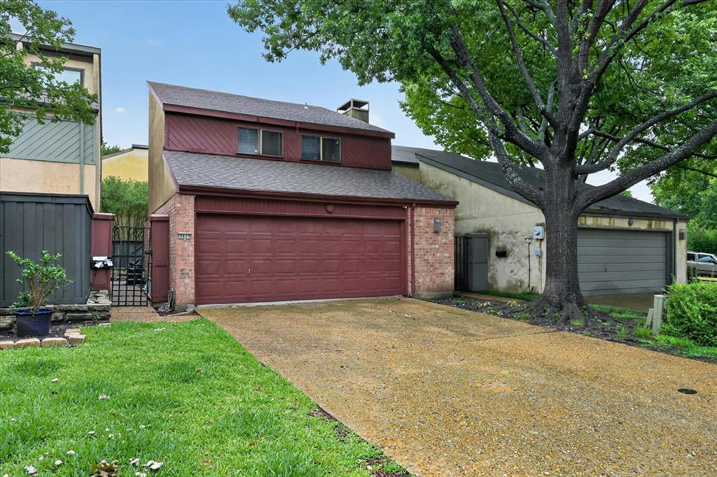 9809 Matchpoint Place Dallas, TX 75243 - Photo 2 of 21 Two-story property featuring a brick facade accent, a two-car garage with a reddish-brown door, and a pitched roof