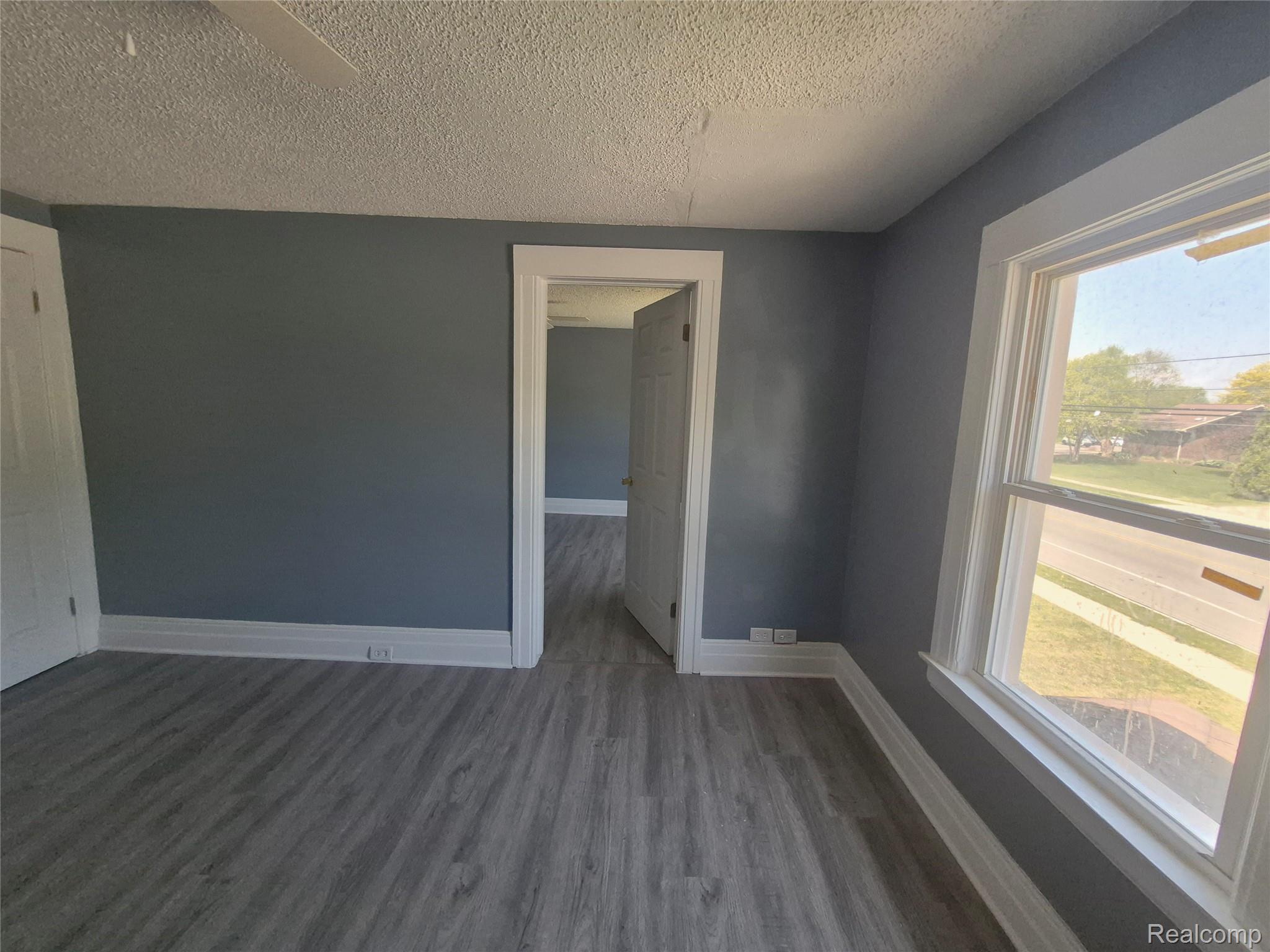 16758 Frazho Road Roseville, MI 48066 - Photo 40 of 53 Wood-finish flooring, neutral wall paint, white trim, and a window providing natural illumination
