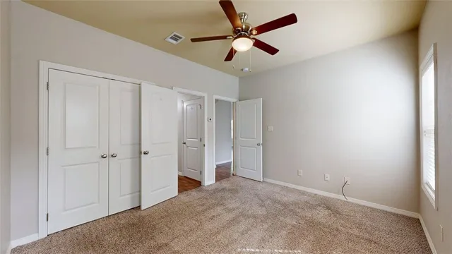 a view of a room with a ceiling fan and hardwood floor