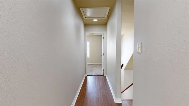 a view of a hallway with wooden floor and entryway