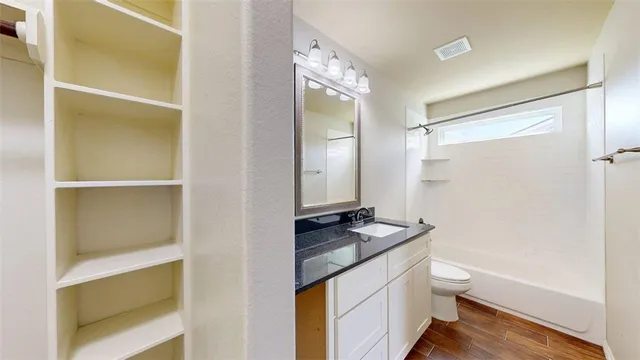 a bathroom with a granite countertop sink toilet and shower