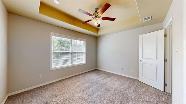 an empty room with ceiling fan and window