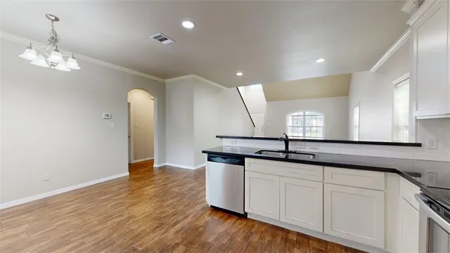 a kitchen with a stainless steel appliances and wooden floor