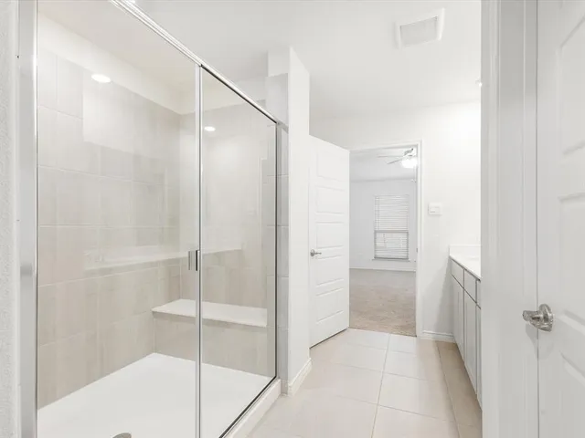 a bathroom with a shower and a glass door