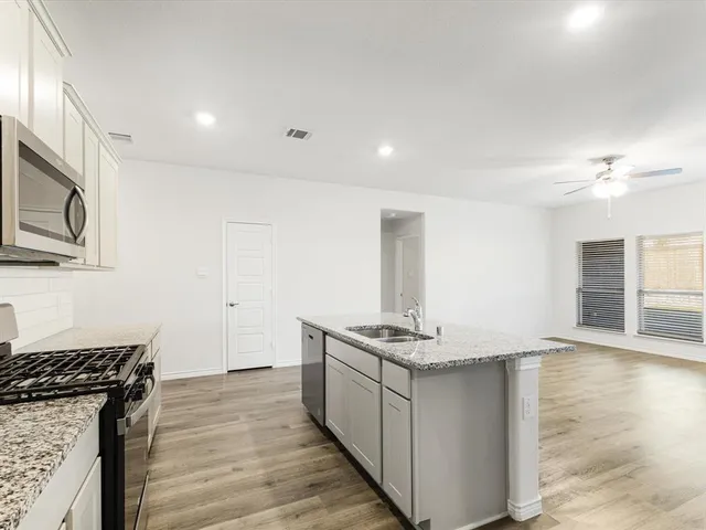a kitchen with stainless steel appliances granite countertop a stove and a sink