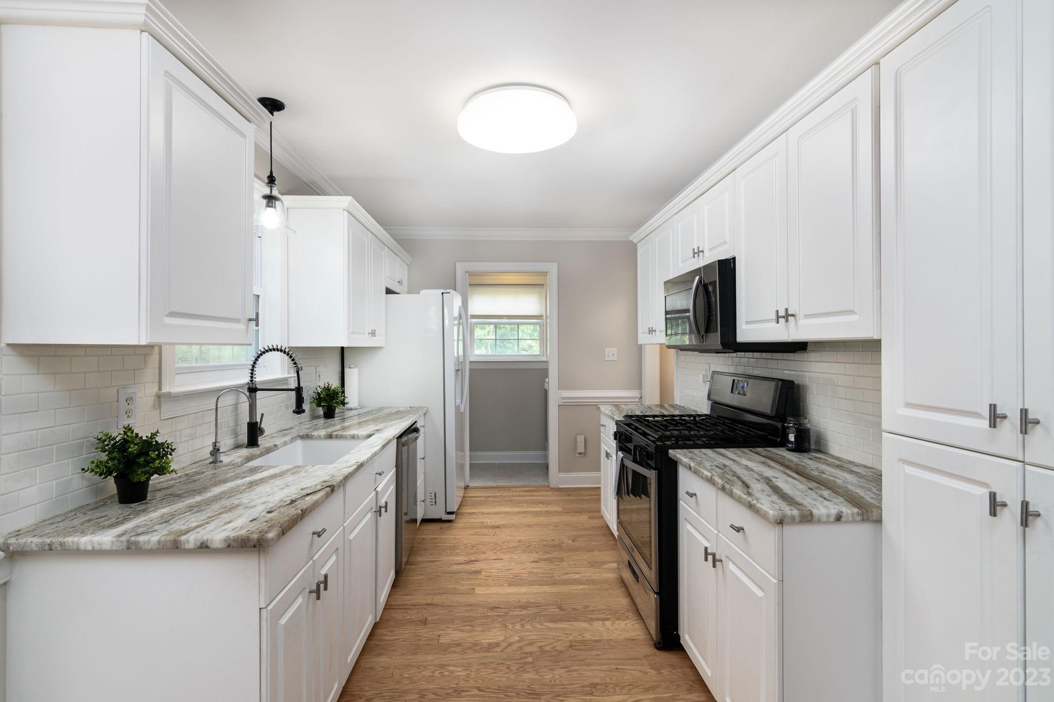 12129 Woodholm Court Tega Cay, SC 29708 - Photo 11 of 27 a kitchen with stainless steel appliances granite countertop a sink stove and microwave