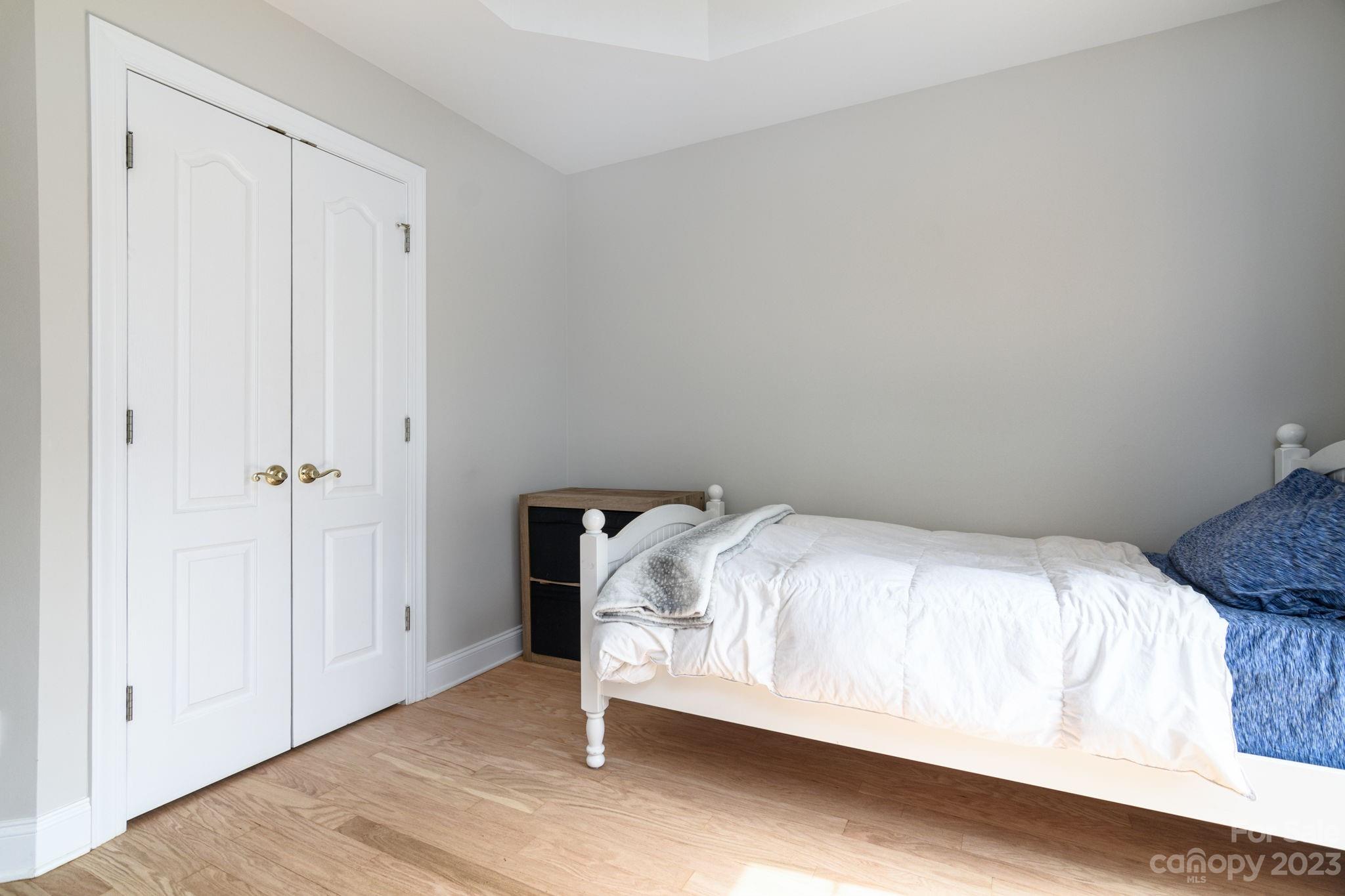 12129 Woodholm Court Tega Cay, SC 29708 - Photo 20 of 27 a bedroom with a bed and a wooden floor