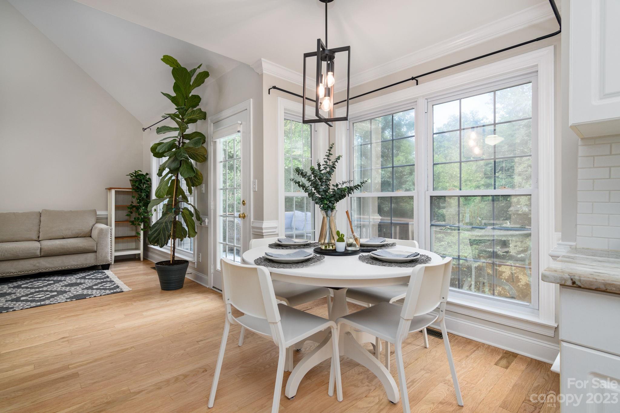 12129 Woodholm Court Tega Cay, SC 29708 - Photo 8 of 27 a dining room with furniture potted plants and wooden floor