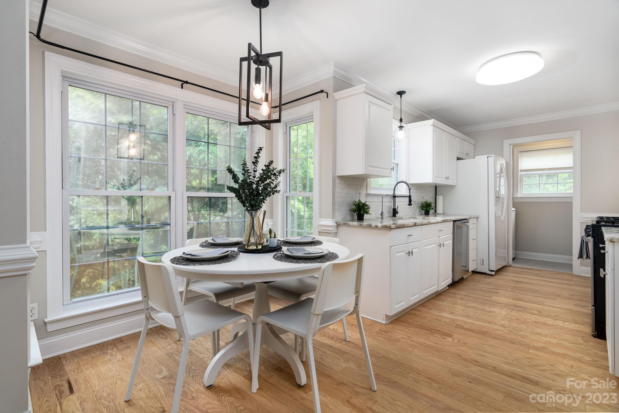 12129 Woodholm Court Tega Cay, SC 29708 - Photo 9 of 27 a kitchen with stainless steel appliances kitchen island a table and chairs in it