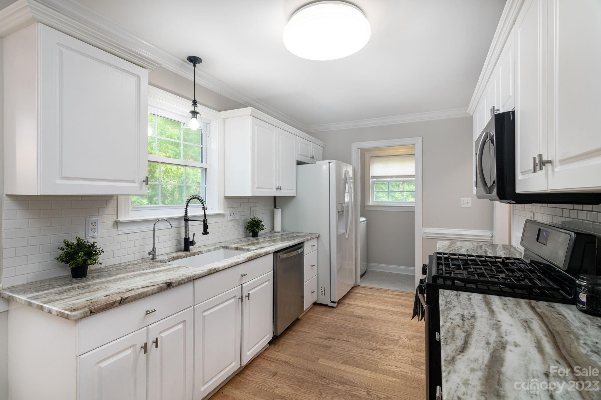 12129 Woodholm Court Tega Cay, SC 29708 - Photo 10 of 27 a kitchen with a sink stove and cabinets