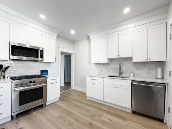 a kitchen with stainless steel appliances a refrigerator stove microwave and sink